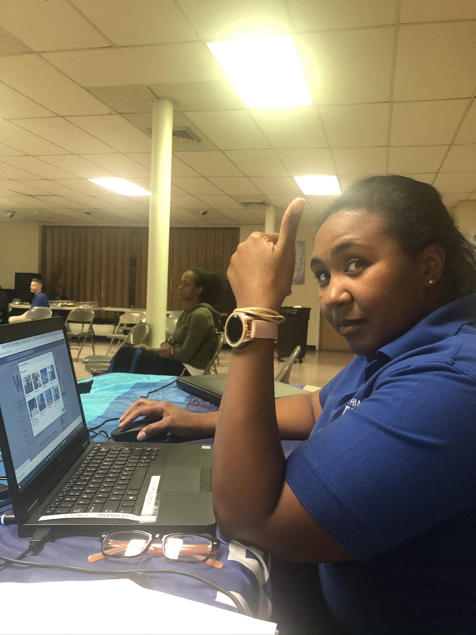 Online Customer Service Specialist Saterria Kersey pauses work on her laptop to give a thumbs-up
