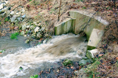 water from a combined sewer outfall overflows into a stream after a heavy rain