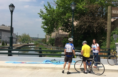 Cyclists in Manayunk stop to ask about the new Waterways artwork. Credit: Philadelphia Water.