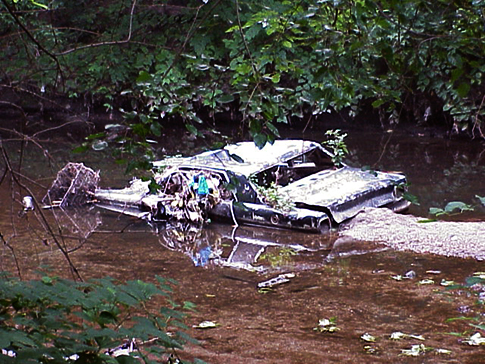 A car rests in a stream in the city's Northeast. Credit: Waterways Restoration Team,