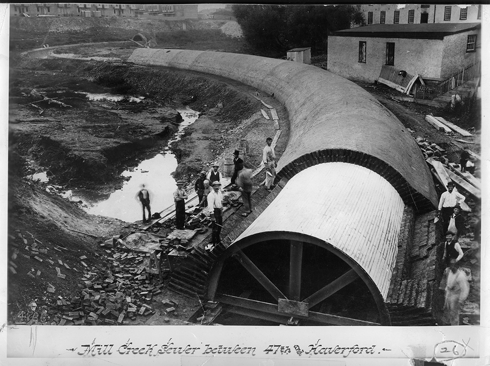 A historic photo shows Mill Creek Sewer under construction in 1887, looking upstream towards 47th Street and Fairmount Avenue.