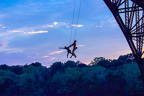 Performers from INVISIBLE RIVER 2014 hang suspended from the Strawberry Mansion Bridge. Credit: INVISIBLE RIVER.