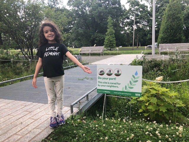 Yahara Spahr, 5, stands in a rain garden that the Centenial Parkside CDC helps care for. Her shirt says 'Little Feminist'.