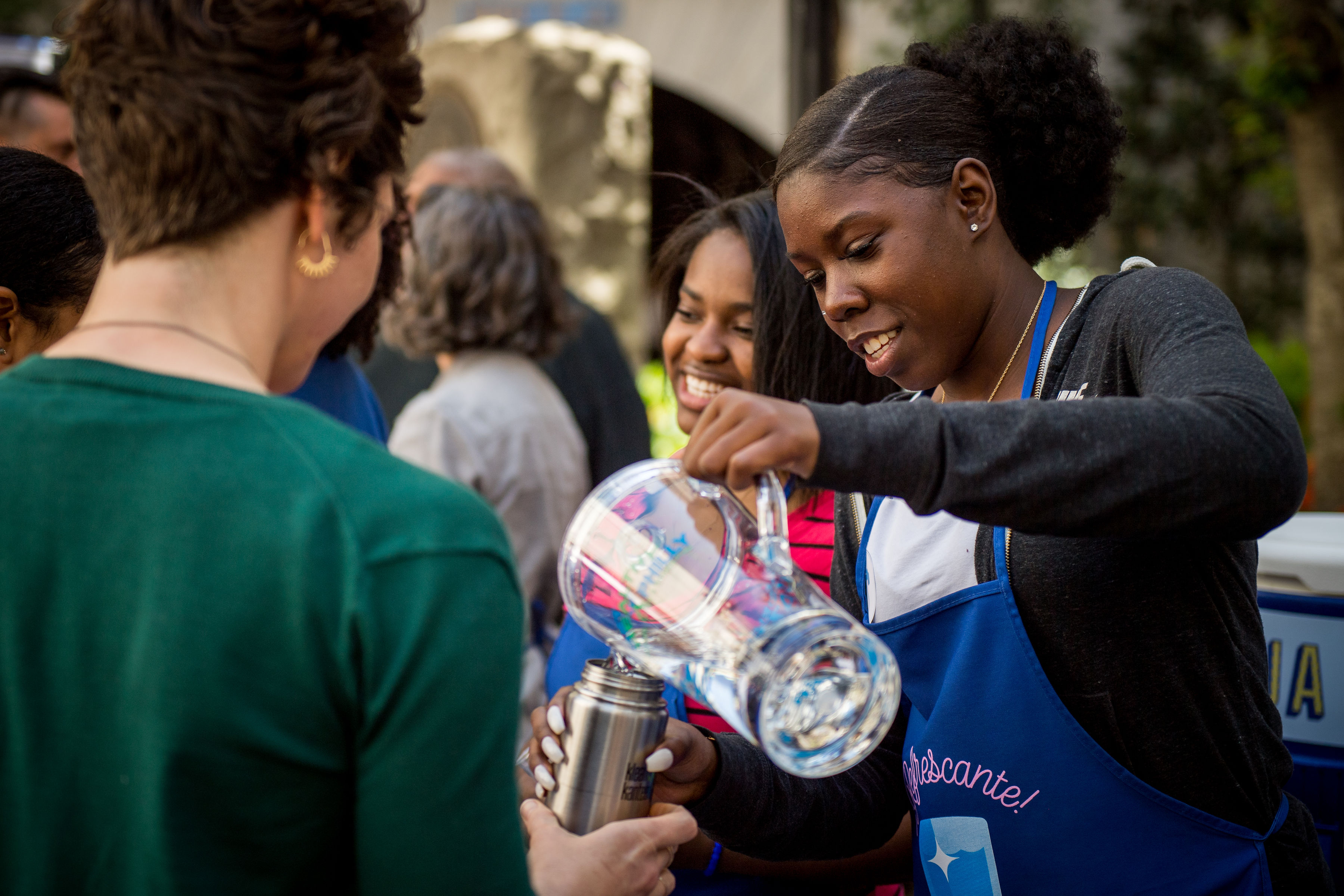 a Philly Water Bar "bartender" pouring cold, refreshing Philly tap into a patron’s reusable water bottle