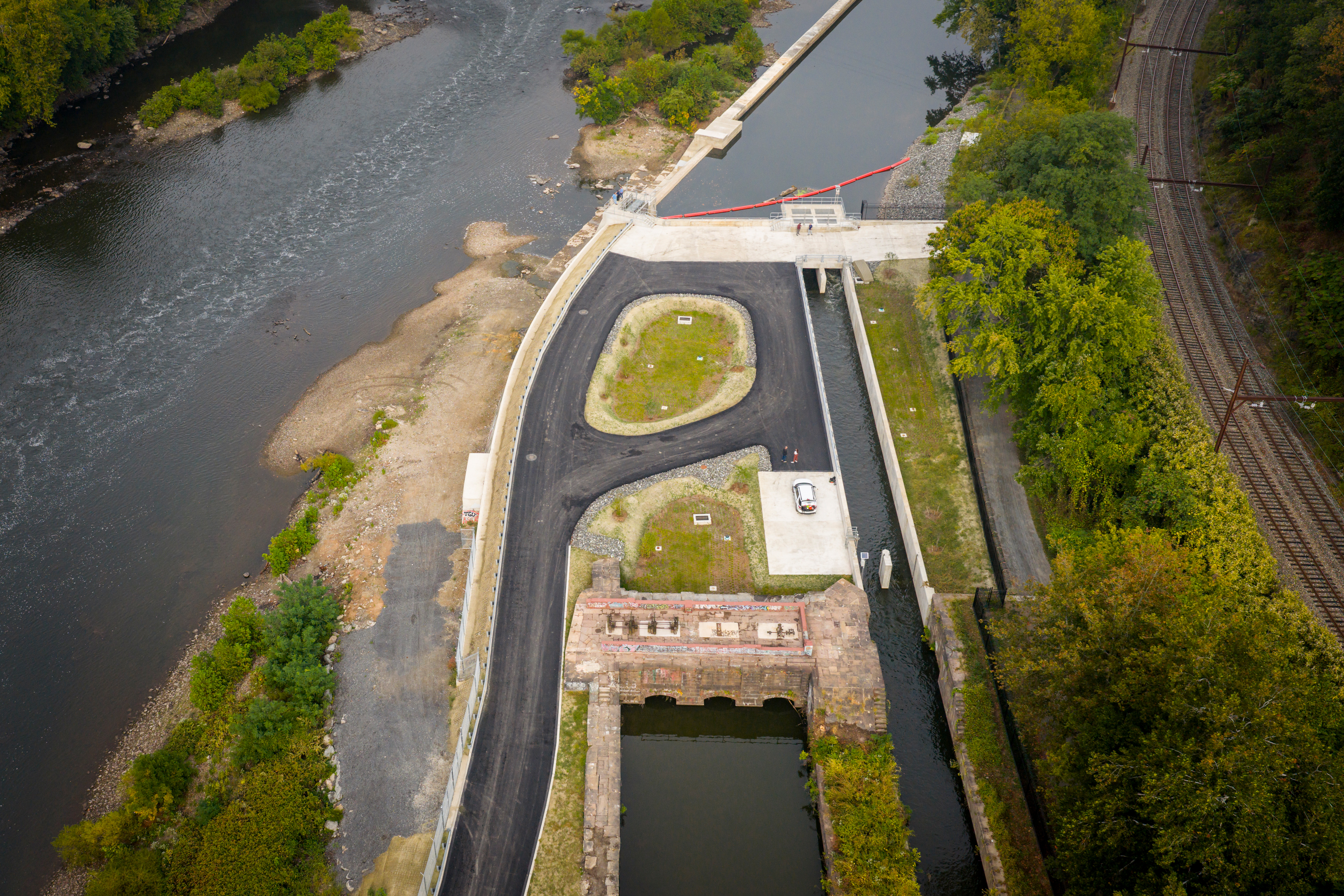 An aerial view of the newly refinished Flat Rock Dam in Manayunk shows the Schuylkill River on the left, the Manayunk Canal towards the right, and the reopened dam and related structures in the center.