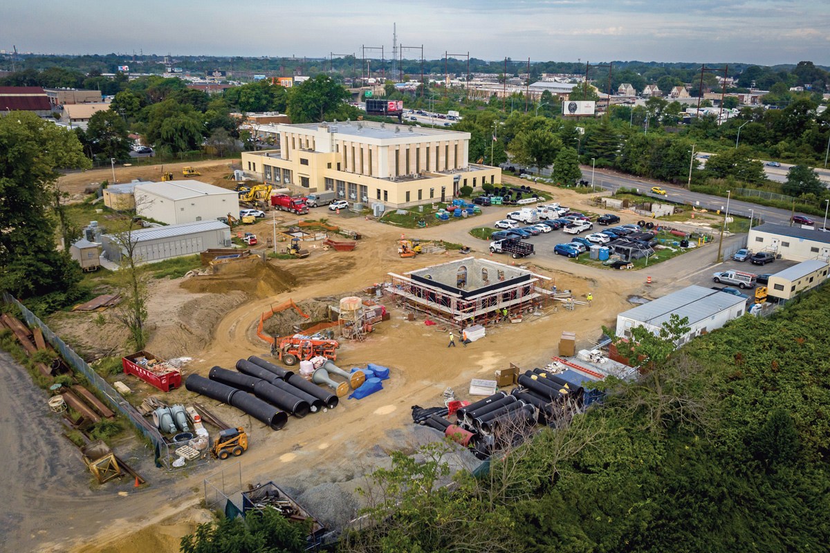 Aerial photo of our Torresdale plant under construction, with scaffolding around one of the buildings, stacks of massive pipe sections, construction vehicles and trailers.
