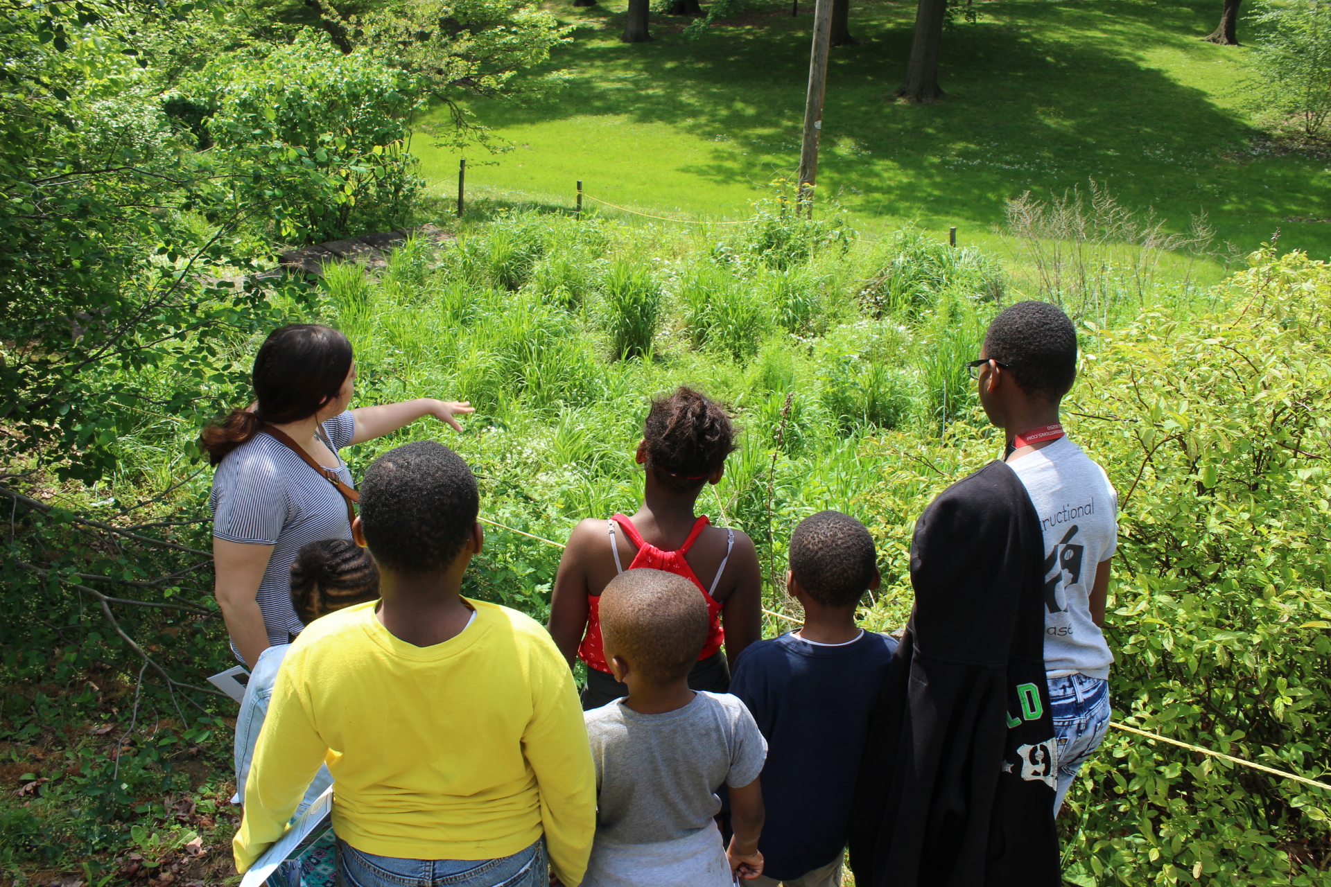 PWD Outreach Specialist Hailey Stern shows a tour group green tools at Cliveden Park